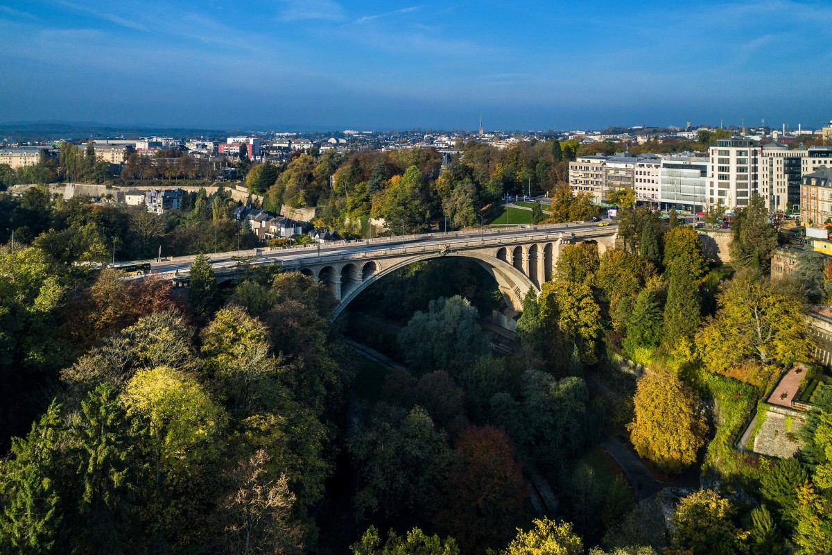 Pétrusse Valley in Luxembourg with Adolphe Bridge, aerial view of green spaces and walking paths.